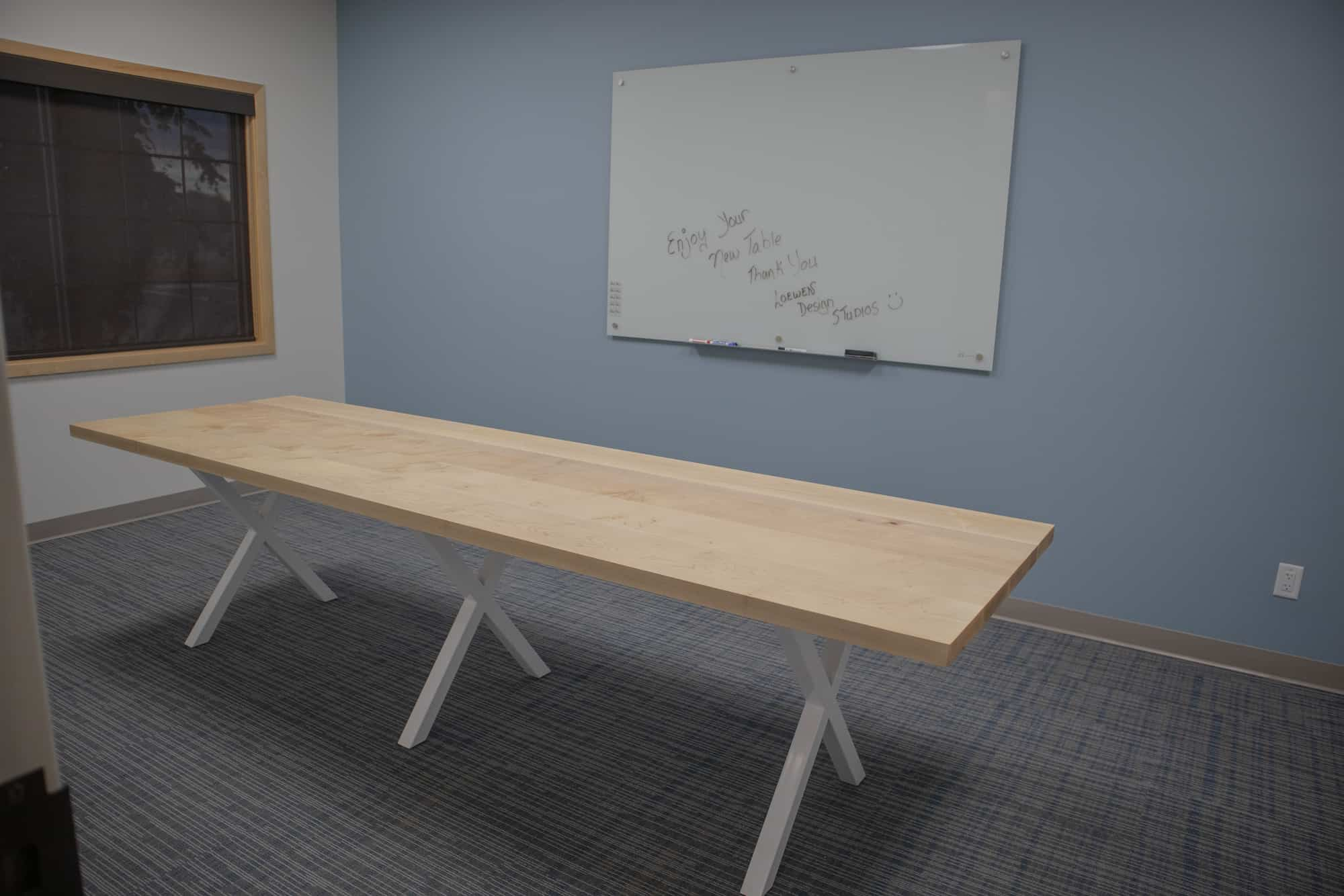 large meeting room table on white steel legs