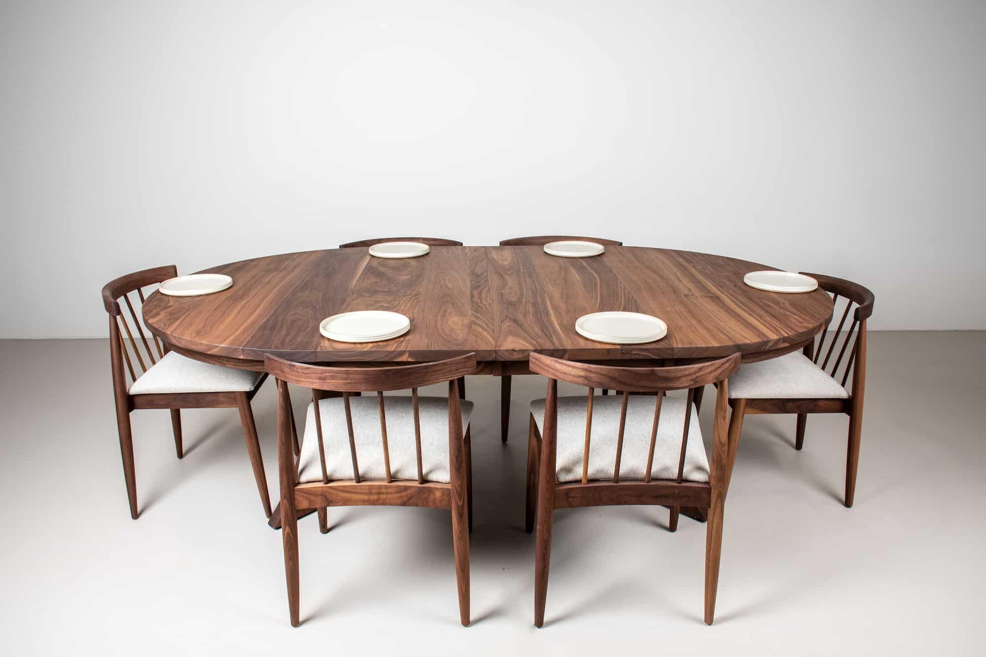 oval dining table with modern walnut chairs