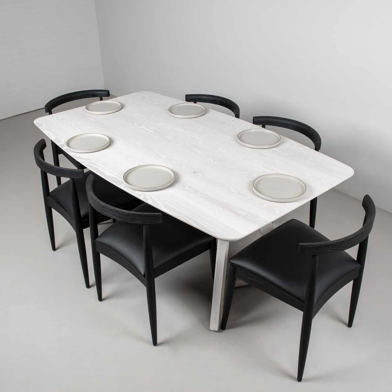 white squoval table with black dining chairs